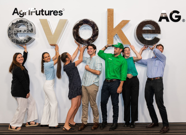 Future Young Leaders cohort in front of the evokeAG sign at evokeAG 2023